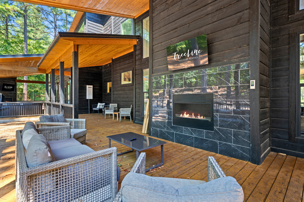 The spacious covered deck brings together comfortable lounge seating and an outdoor fireplace, making it easy to slow down and enjoy the beautiful forest setting.