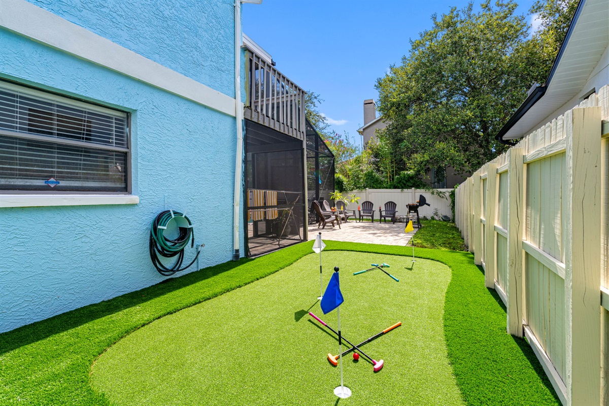 This unique side yard is home to a playful putting green and bright cornhole boards—great for casual fun or a little friendly competition.