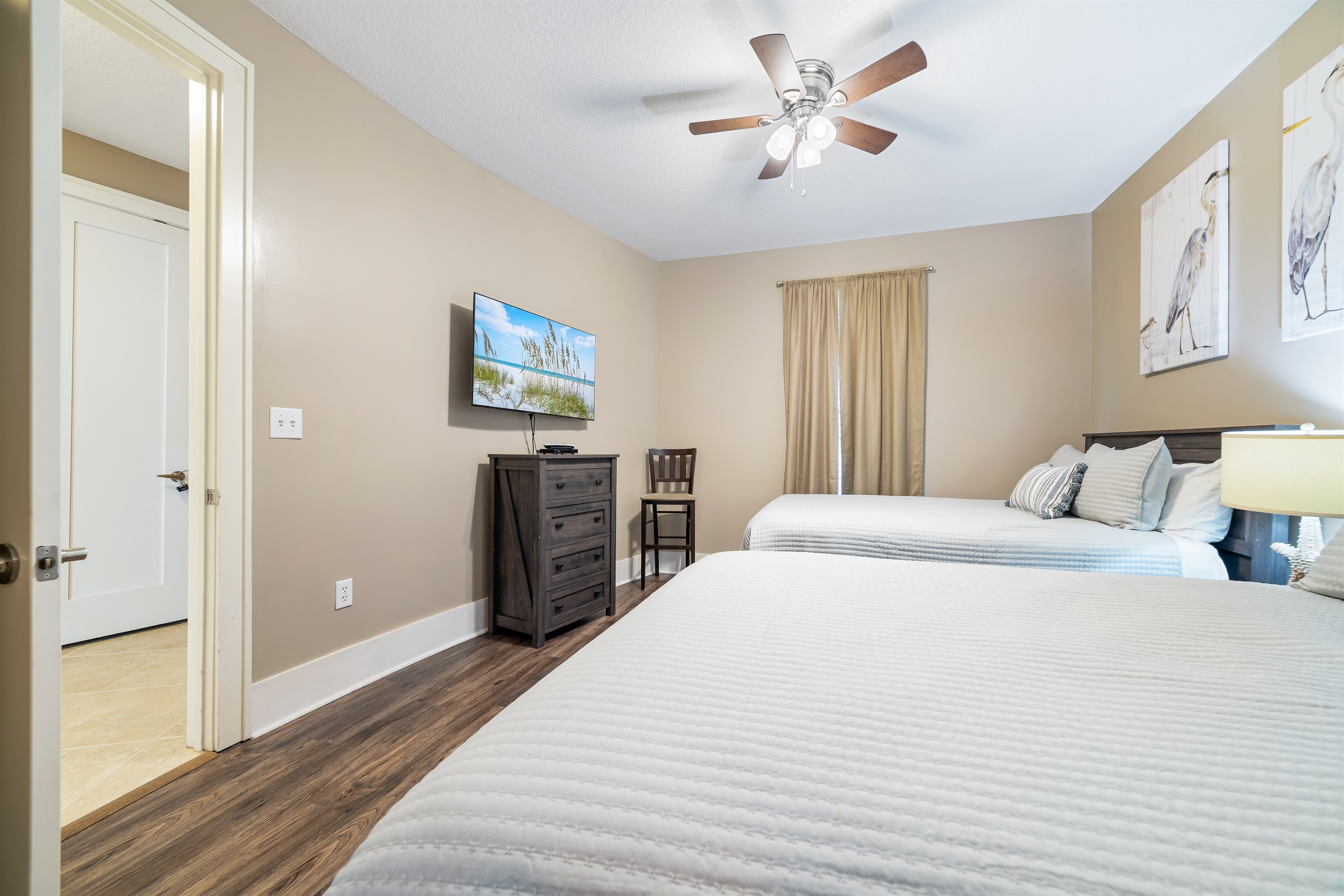 Bright and airy bedroom with two Queen beds, offering a comfortable and inviting space for guests.