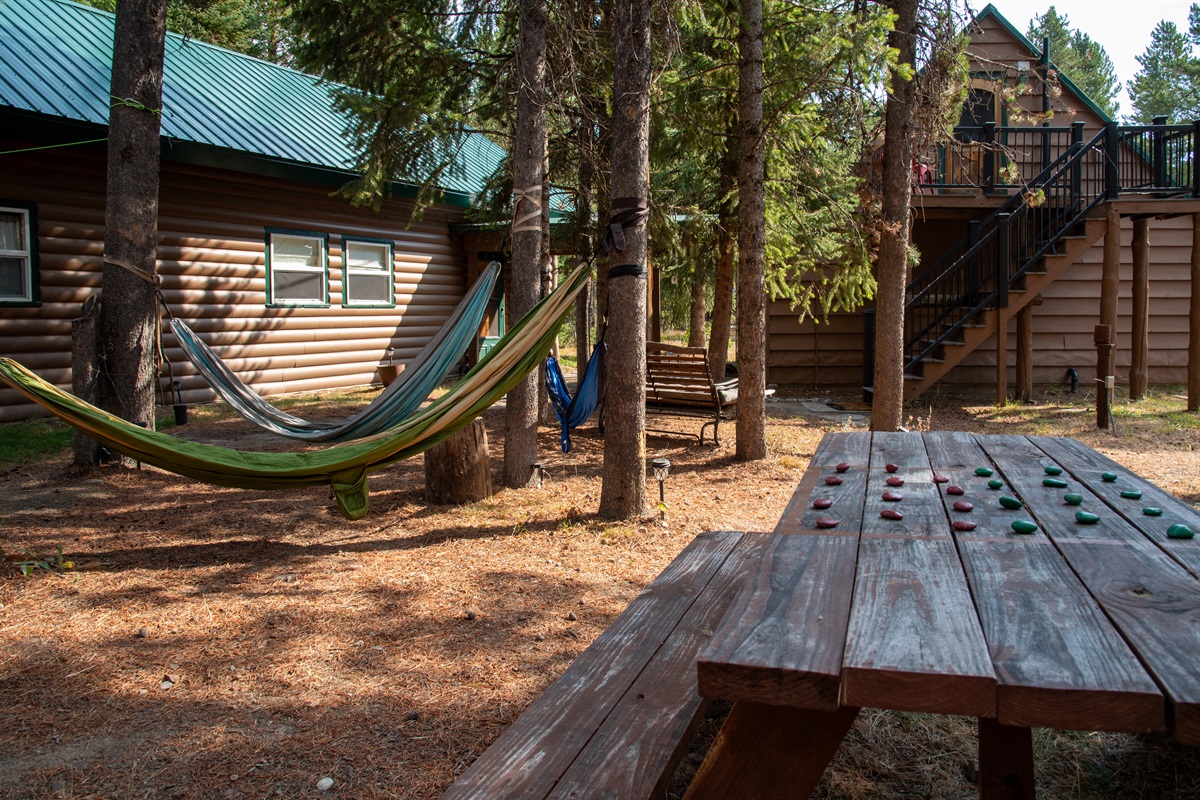 Checkerboard picnic table with hammocks and stairs to the detached garage bedroom