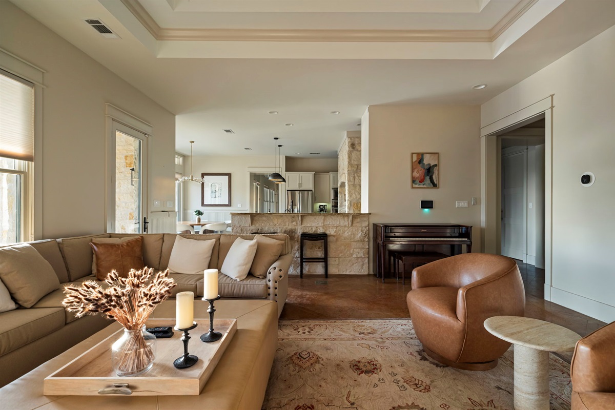 A warm and inviting living space designed for comfort and elegance, featuring plush seating, natural light, and a dedicated music nook, perfect for relaxation and entertaining.