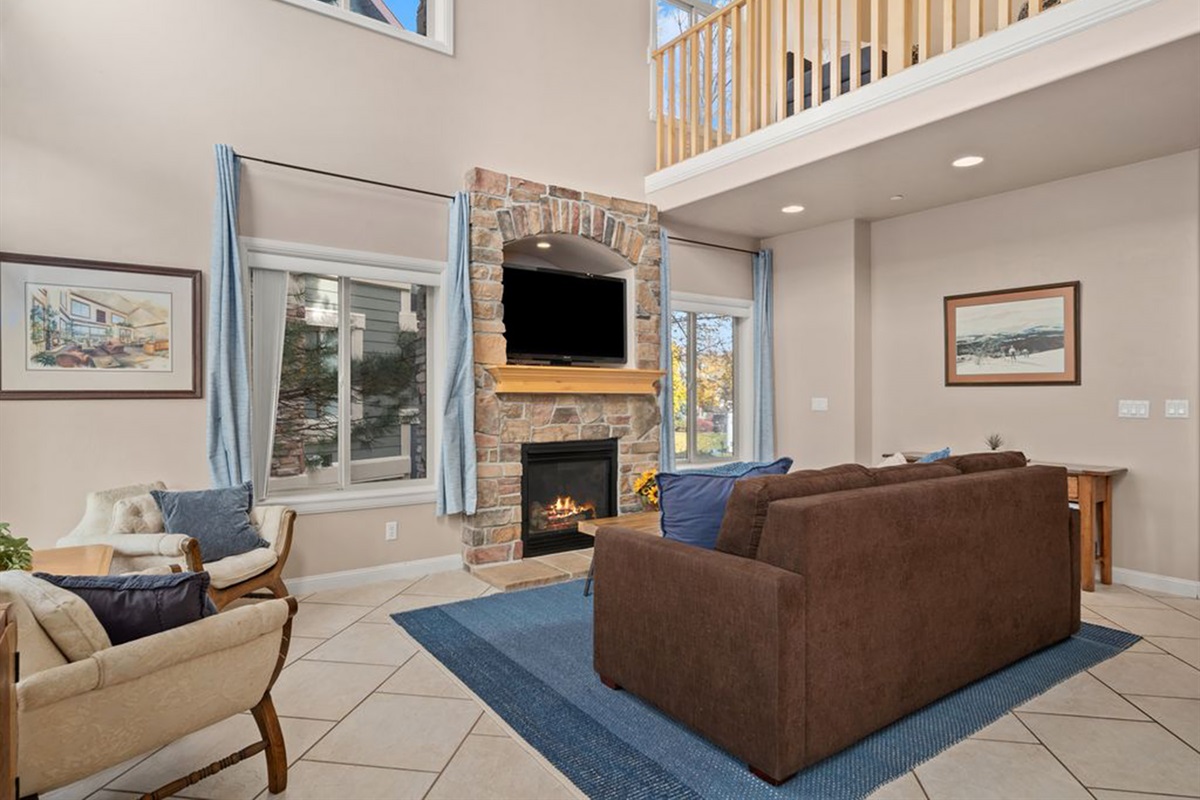 Inviting living area with cozy gas fireplace and open loft above.
