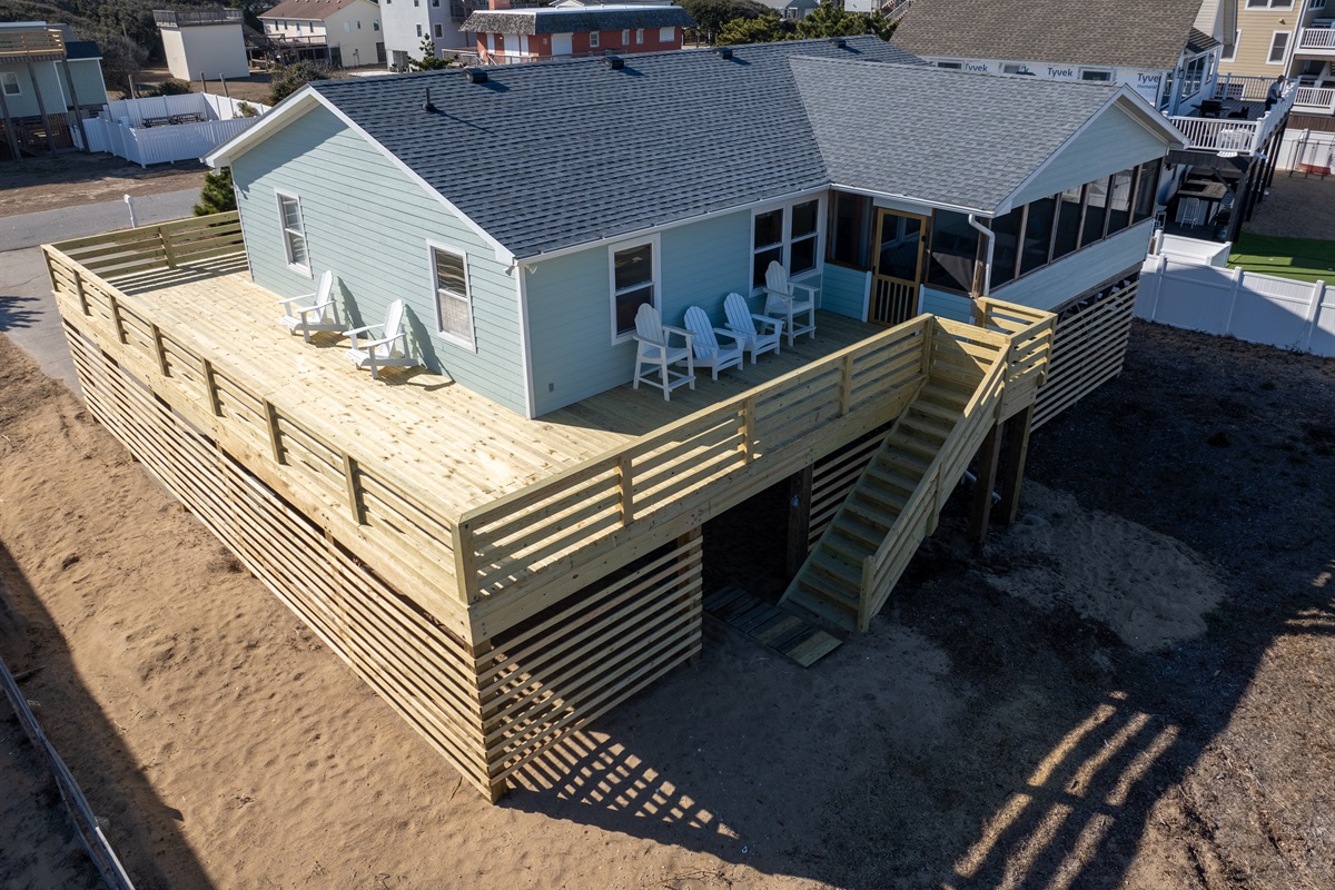 New deck that wraps around three sides of the house. Plenty of Adirondack chairs to relax in the sun.