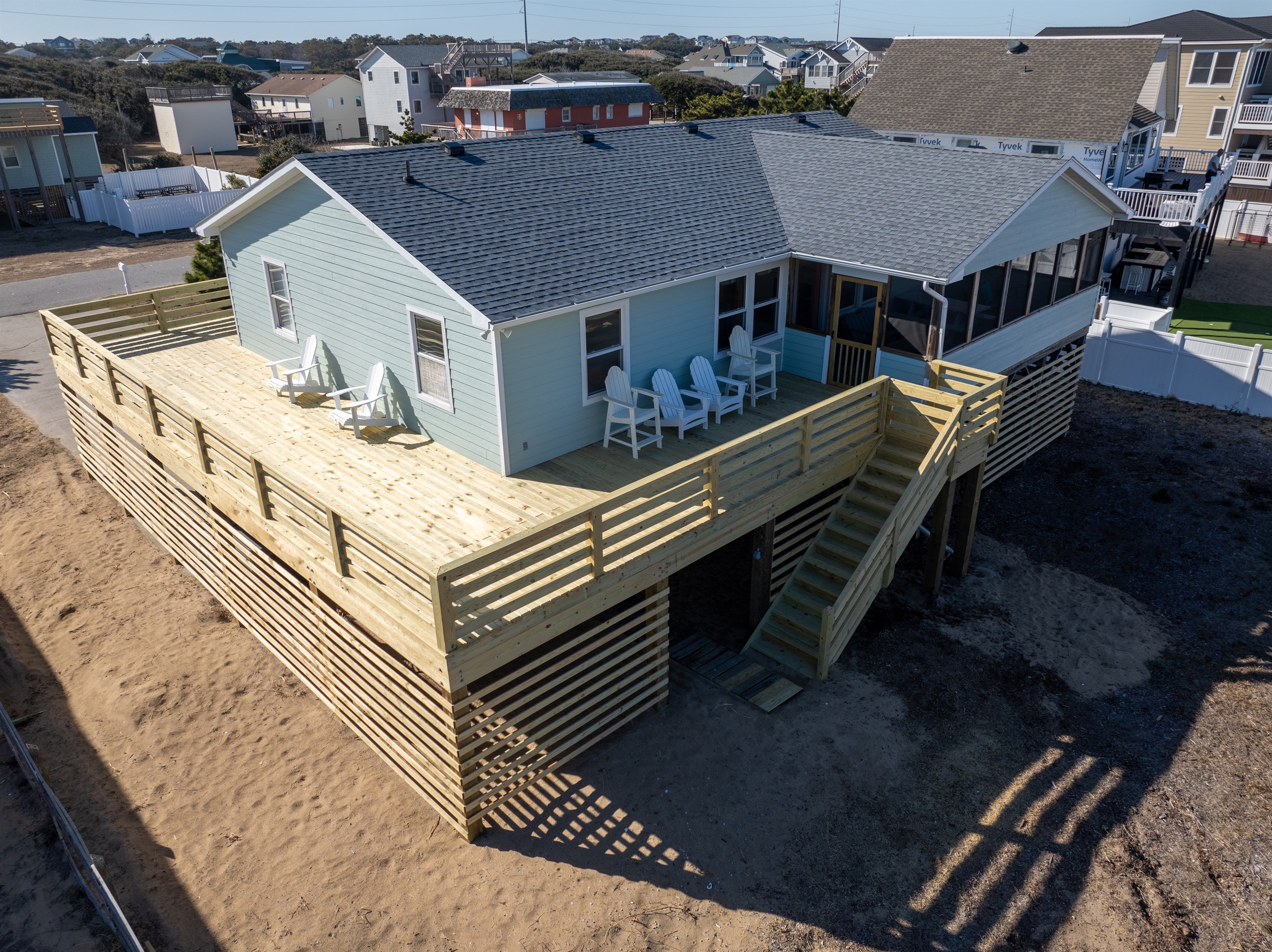New deck that wraps around three sides of the house. Plenty of Adirondack chairs to relax in the sun.