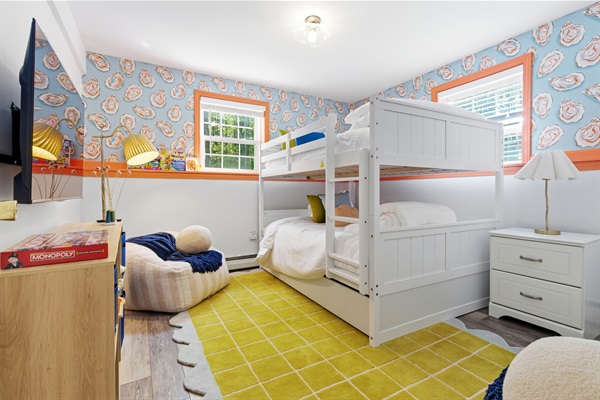 A fun and comfortable room featuring bunk beds, cozy bean bags, and a TV, perfect for relaxing, hanging out, and enjoying downtime.