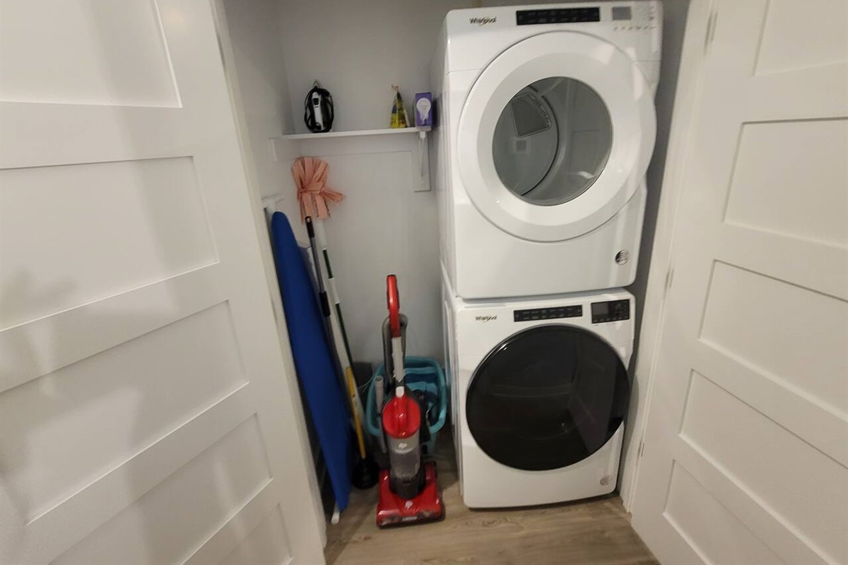 Full-size washer and dryer, ironing board and iron, vacuum, broom and laundry basket.