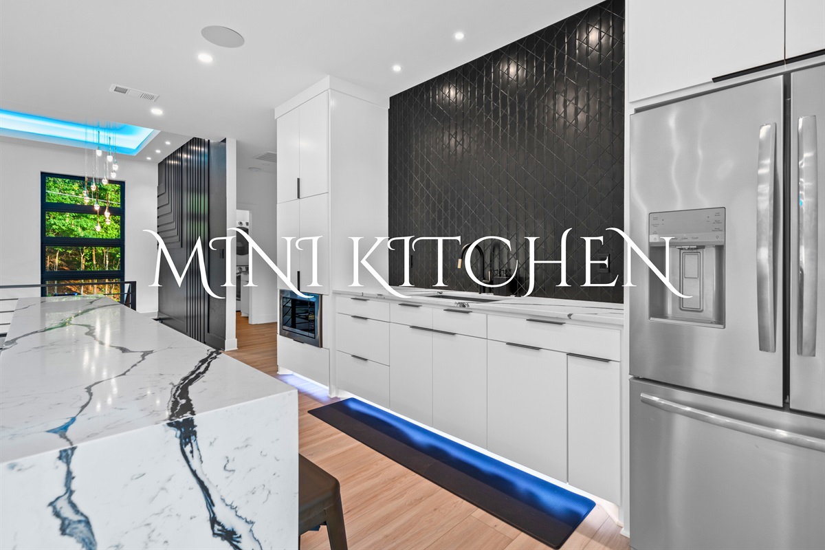 The mini kitchen is compact yet fully equipped with modern appliances and stylish finishes for culinary convenience.