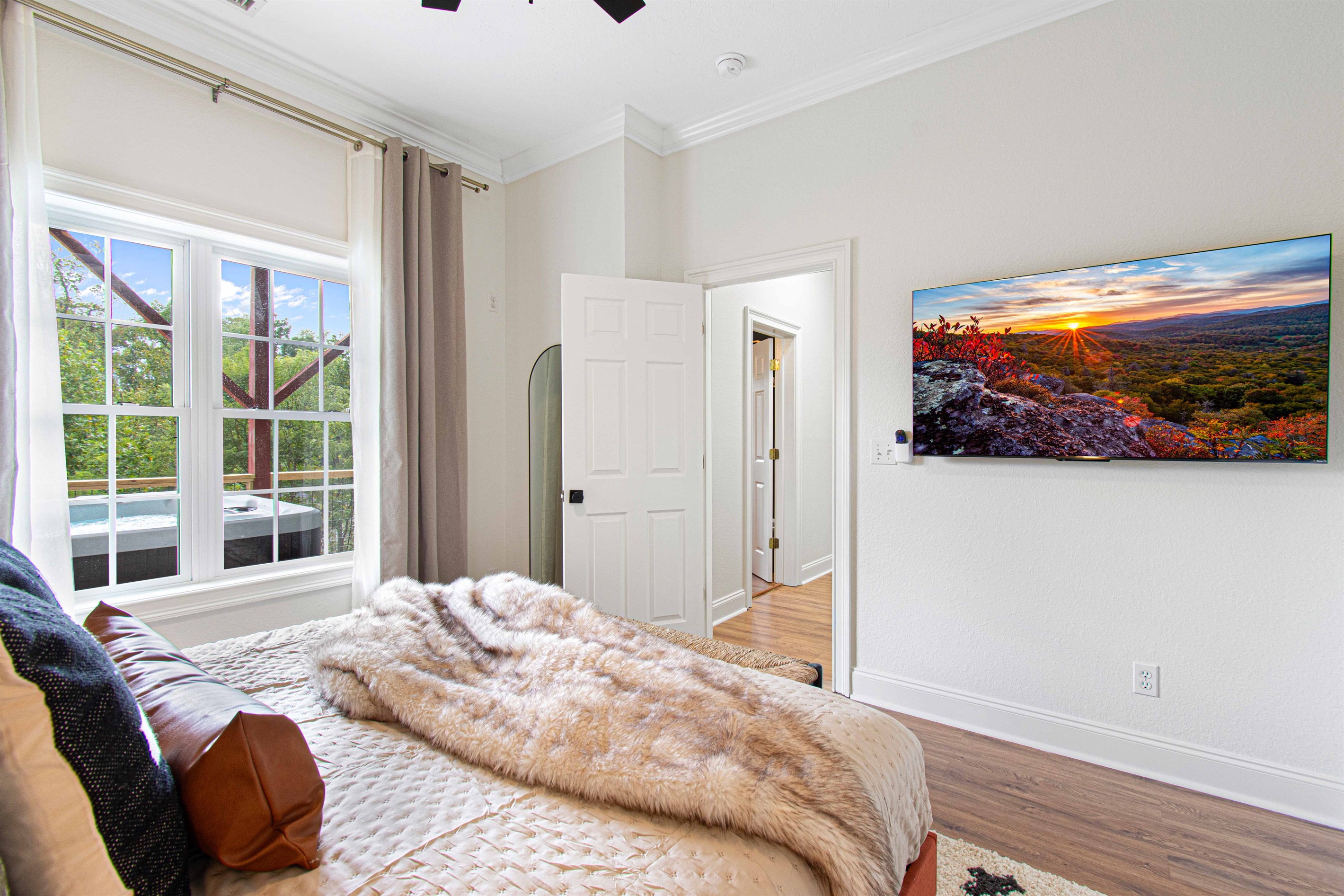 Unwind in this serene bedroom with soft, luxurious bedding and direct views of the outdoor hot tub. A peaceful retreat for relaxation after a day of adventure.