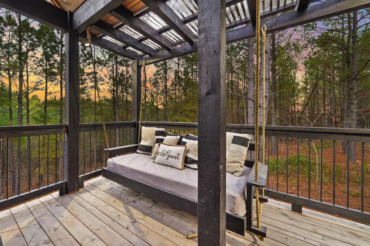 Deck seating with nature views under a covered pergola.
