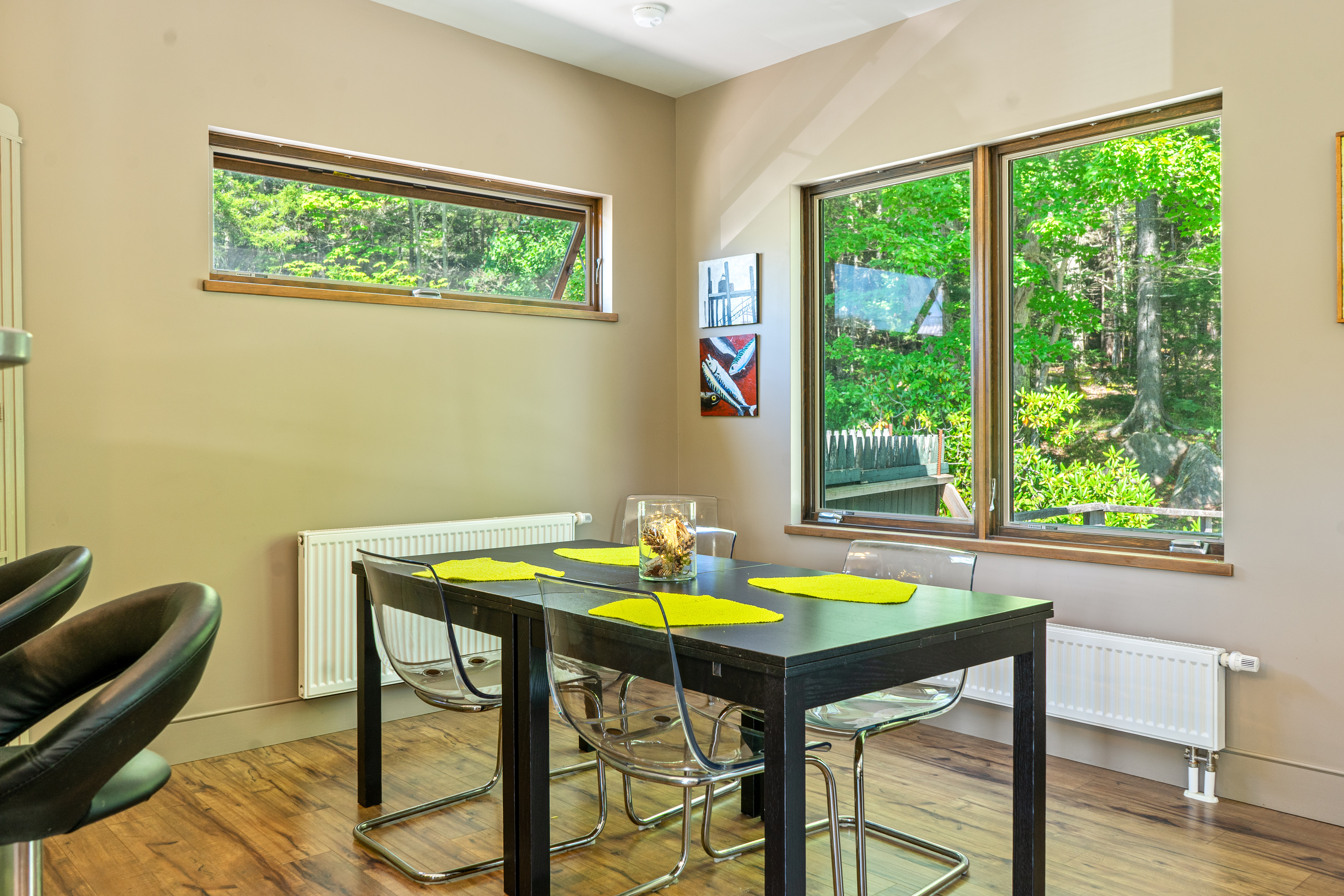 Dine with direct views into Acadia National Park. "The Crag's" main floor dining space features clear modern seating and large picture windows framing the lush forest canopy, bringing nature right to your dinner table.