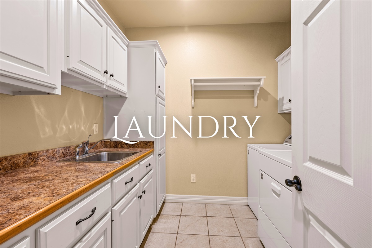 Laundry room with washer, dryer, and ample storage space.