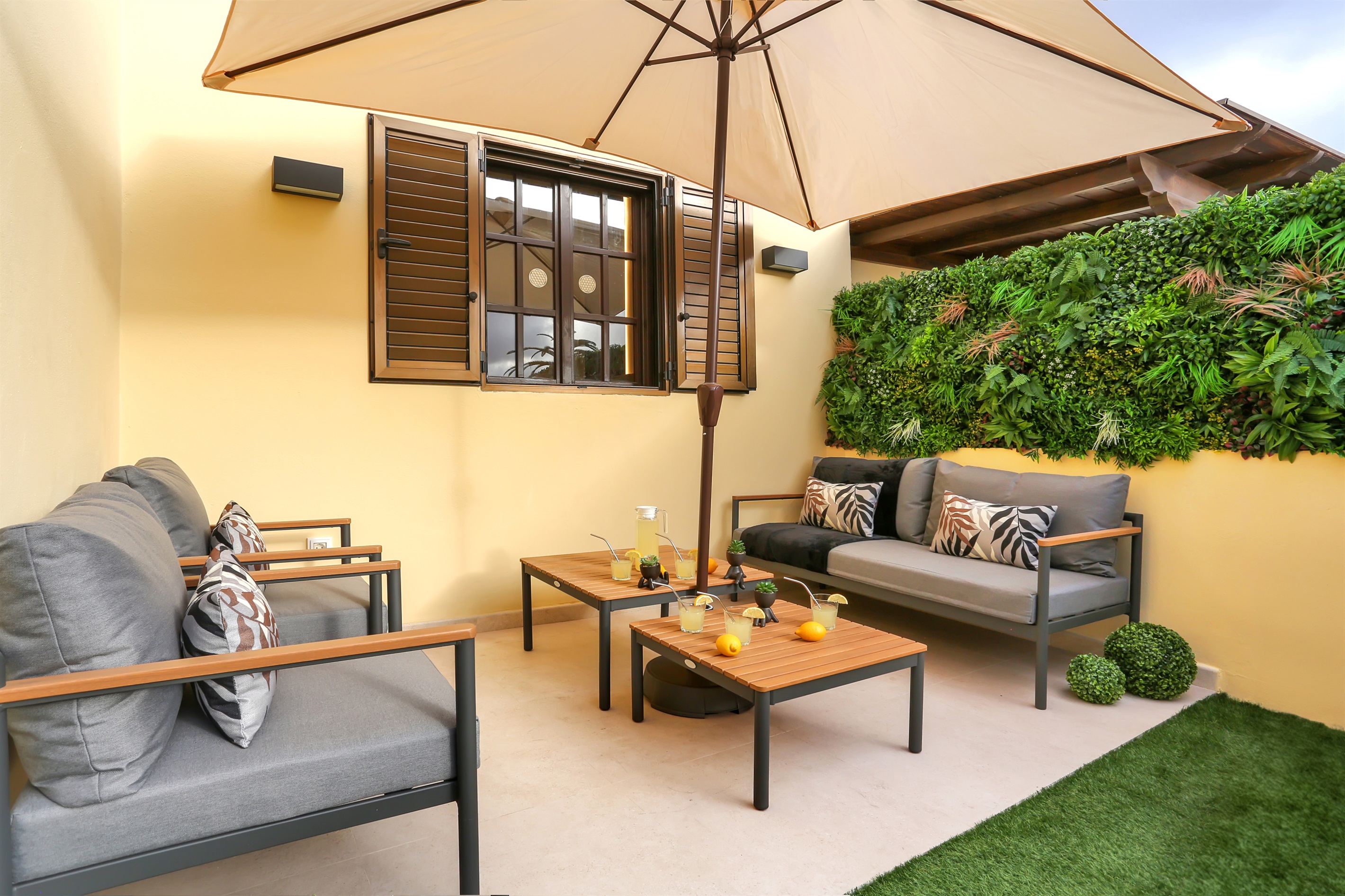 Elegant chill-out area in the private garden with comfortable sofas and an outdoor table, ideal for relaxing and enjoying pleasant moments outdoors.