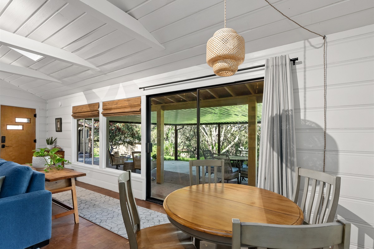 Light-filled dining area with sliding doors opening to the covered outdoor patio.