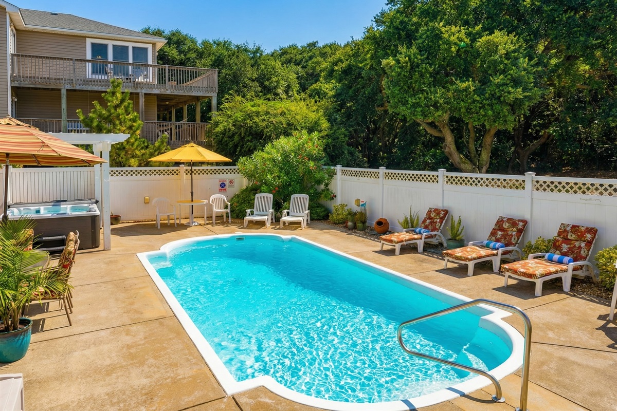 A view of the community amenities, featuring a large soundfront swimming pool and a long private pier with a gazebo for enjoying the water views.