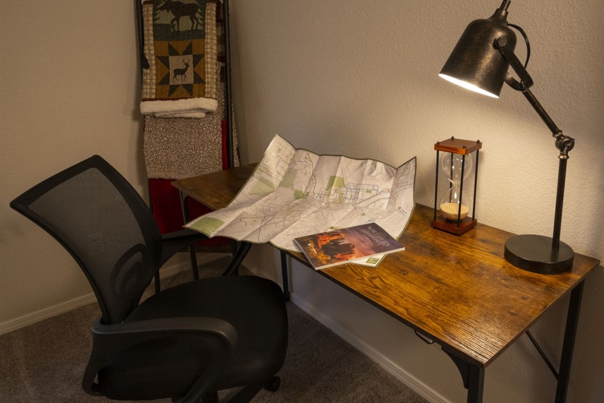 Bedroom workspace with desk, lamp, and chair for work trips or extended visits.