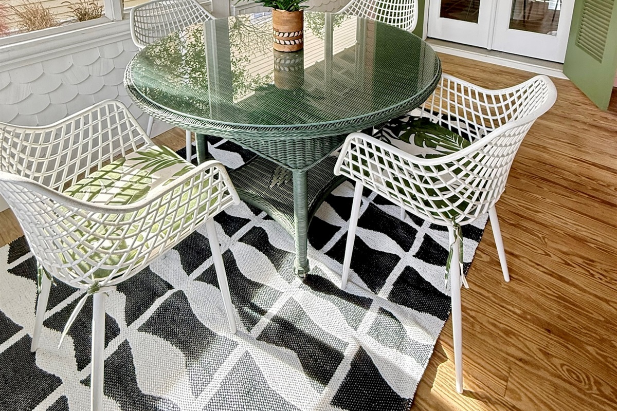 Charming screened porch with outdoor dining—perfect for morning coffee or relaxed coastal meals.