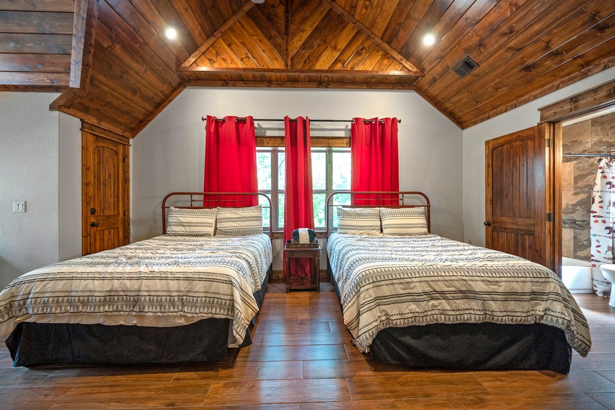 Spacious bedroom with two queen size beds and a fold out futon bed