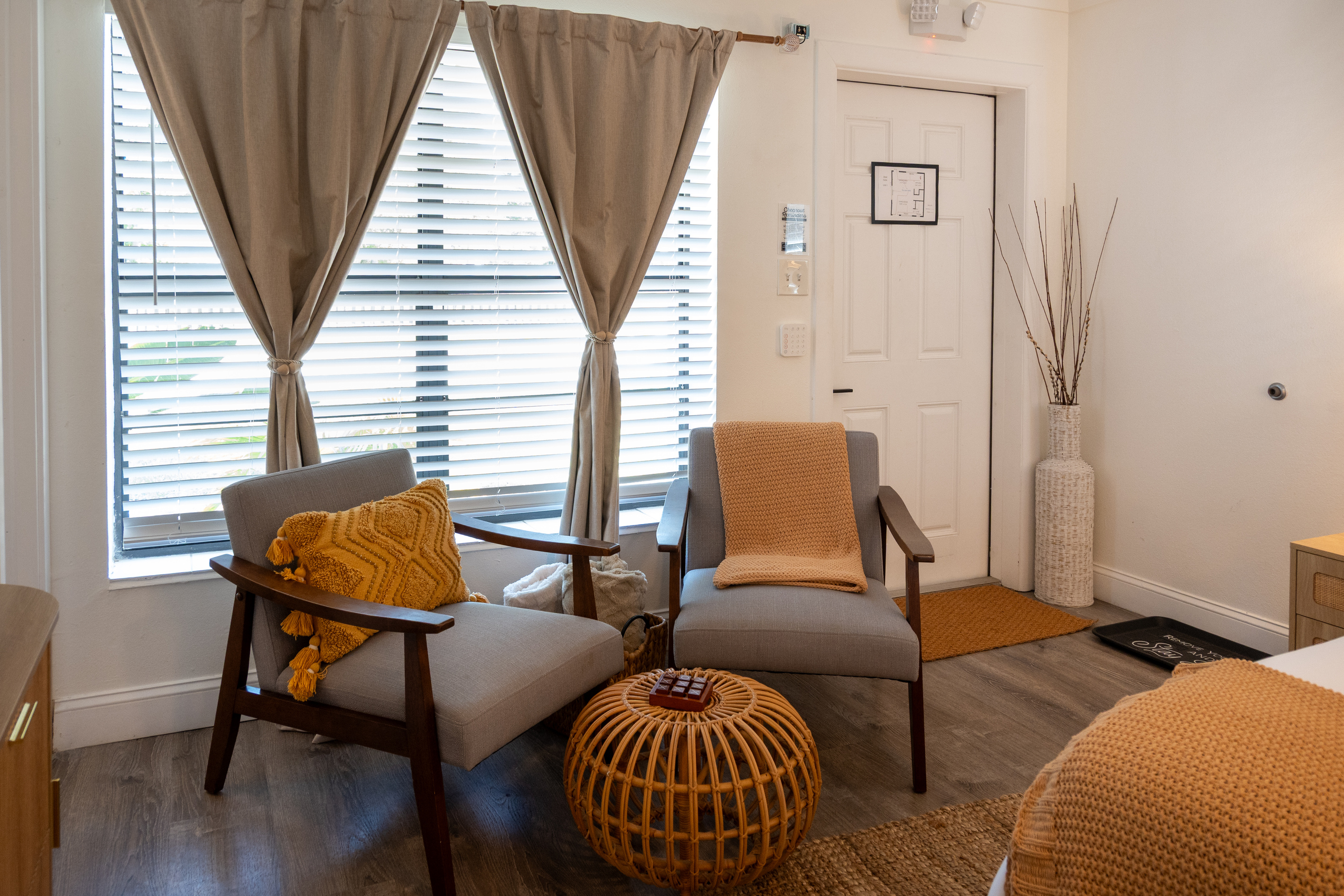 Cozy sitting nook with two armchairs and a rattan ottoman