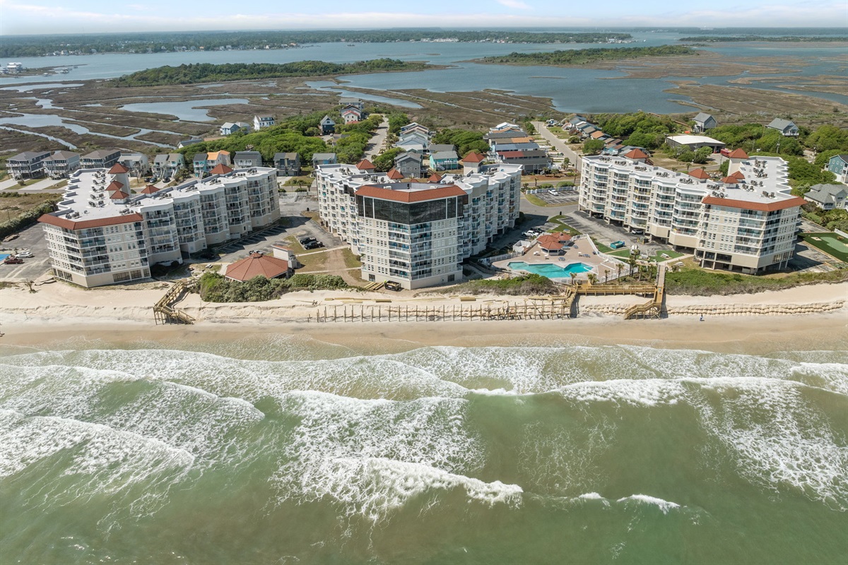Stunning aerial of St. Regis showcasing all three buildings, direct beach access, and expansive coastal views