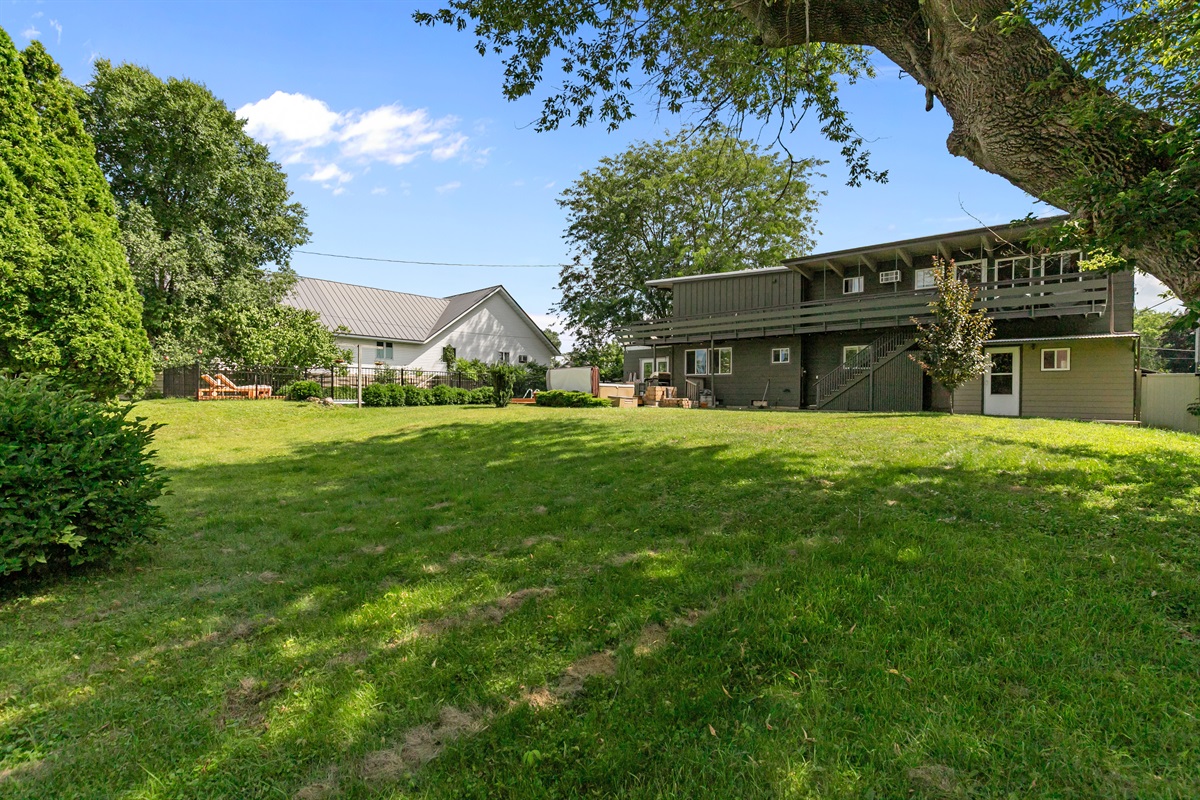 The backyard offers an amazing amount of space, giving everyone room to relax, play, and enjoy the outdoors together.