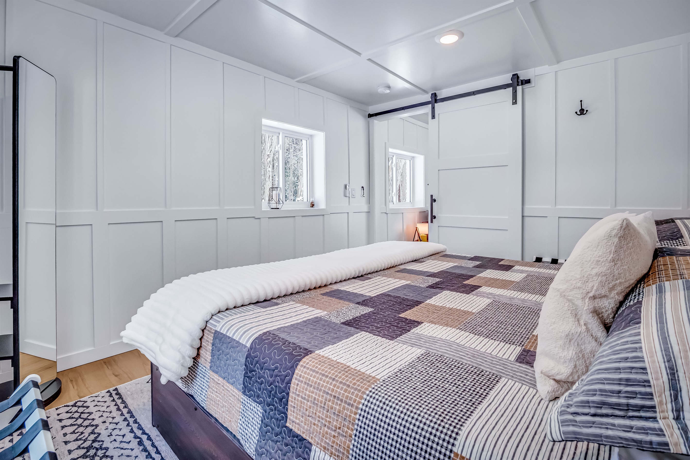2 windows with views of the woods and sunset. Sliding barn door, King bed.