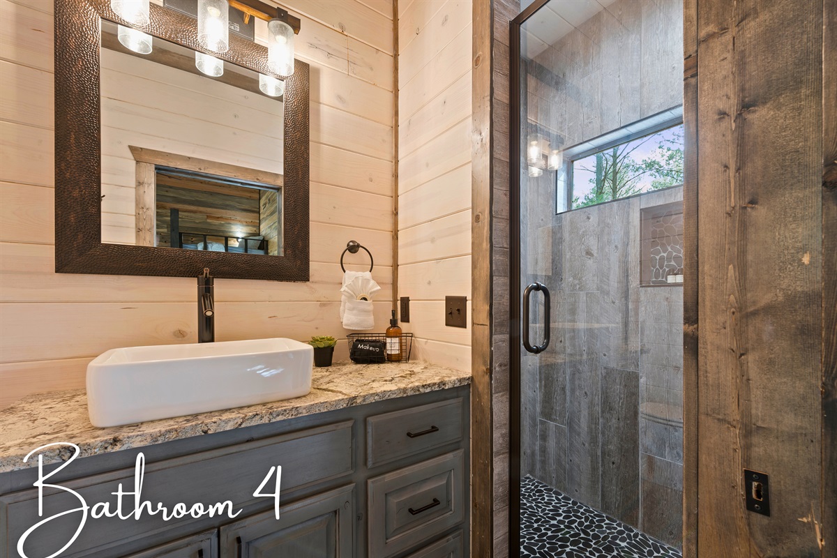 A modern bathroom with dual sinks, contemporary mirrors, and a glass-enclosed shower