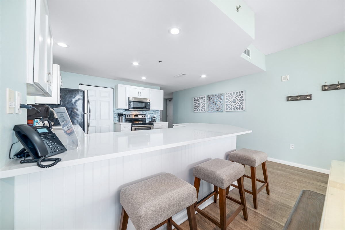 Whip up a feast or enjoy a quick bite! This kitchen and dining area, complete with a breakfast bar for 3, is perfectly set for all your culinary adventures and shared moments.