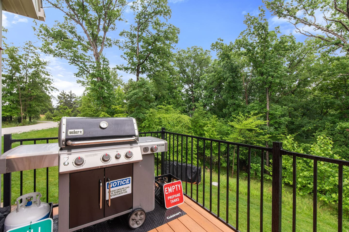 New Weber Genesis gas grill (May 2025). BBQ tongs and spatulas are inside the kitchen island. There will be a propane tank already hooked up, and an extra one in case you need it.