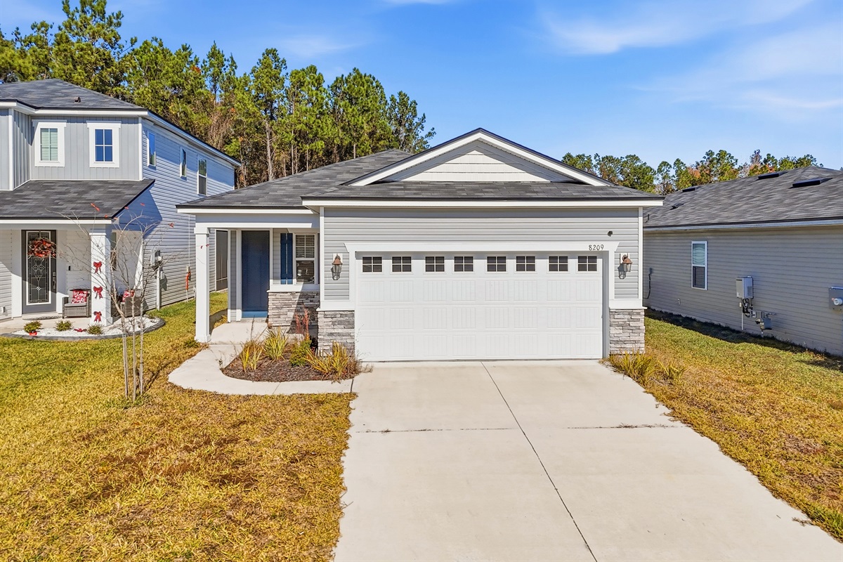 Front of home with large driveway.