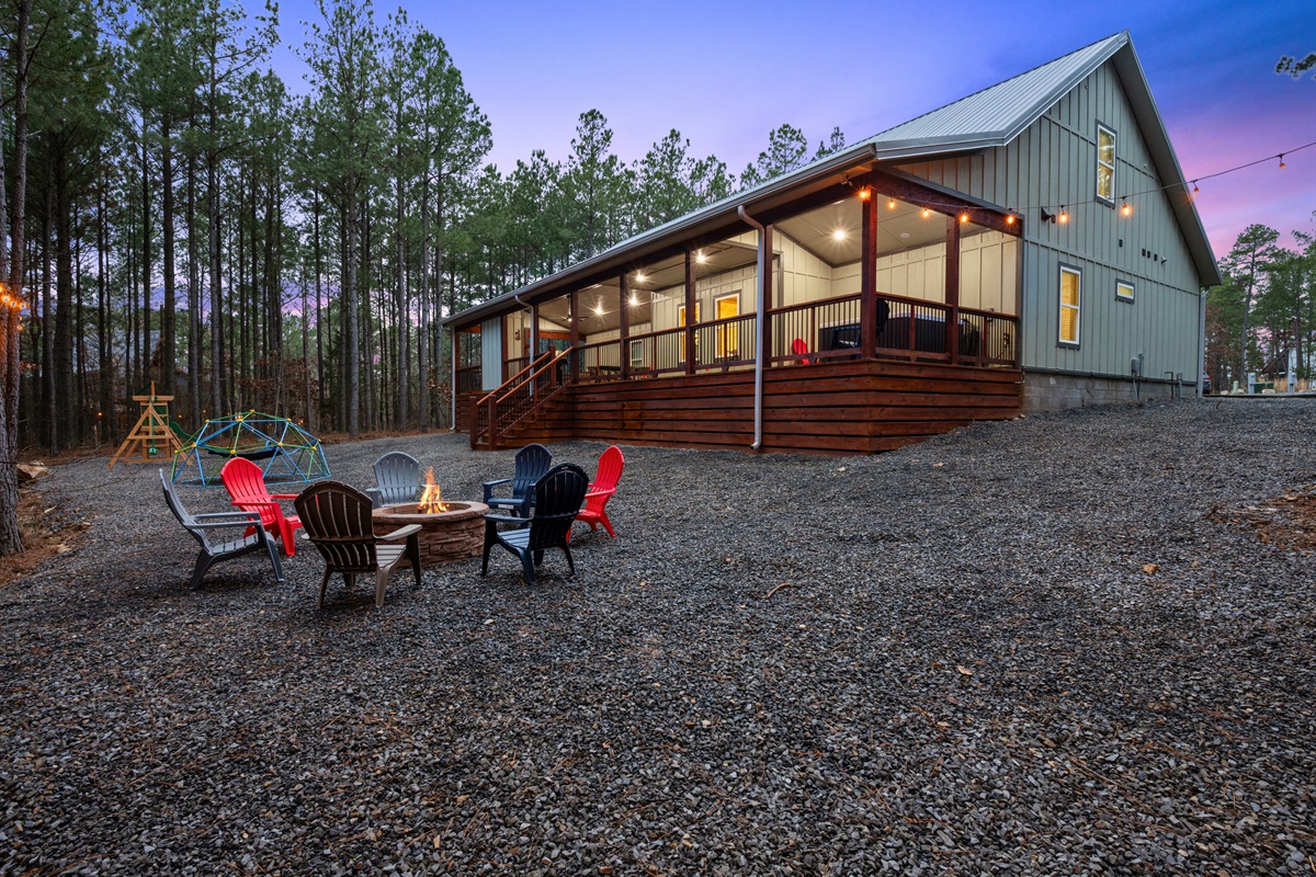 As evening falls, the cabin exterior glows warmly against the tall pine trees, creating a welcoming scene that feels peaceful and secluded.
