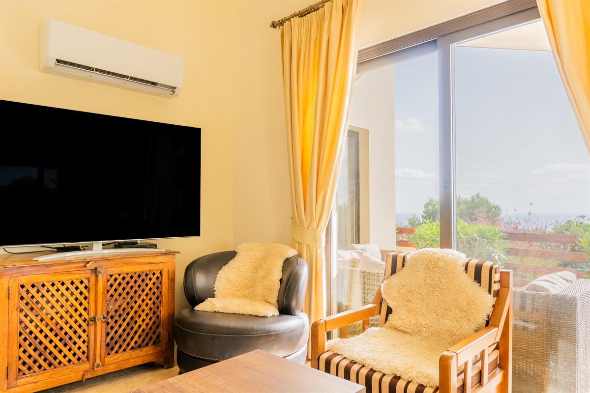 Living room with large-screen TV with international channels, bluray player, bluetooth-enabled sound system, and HDMI cable to connect your own device. Feel free to grab a book from our little library. High-speed internet/Wifi throughout the villa.