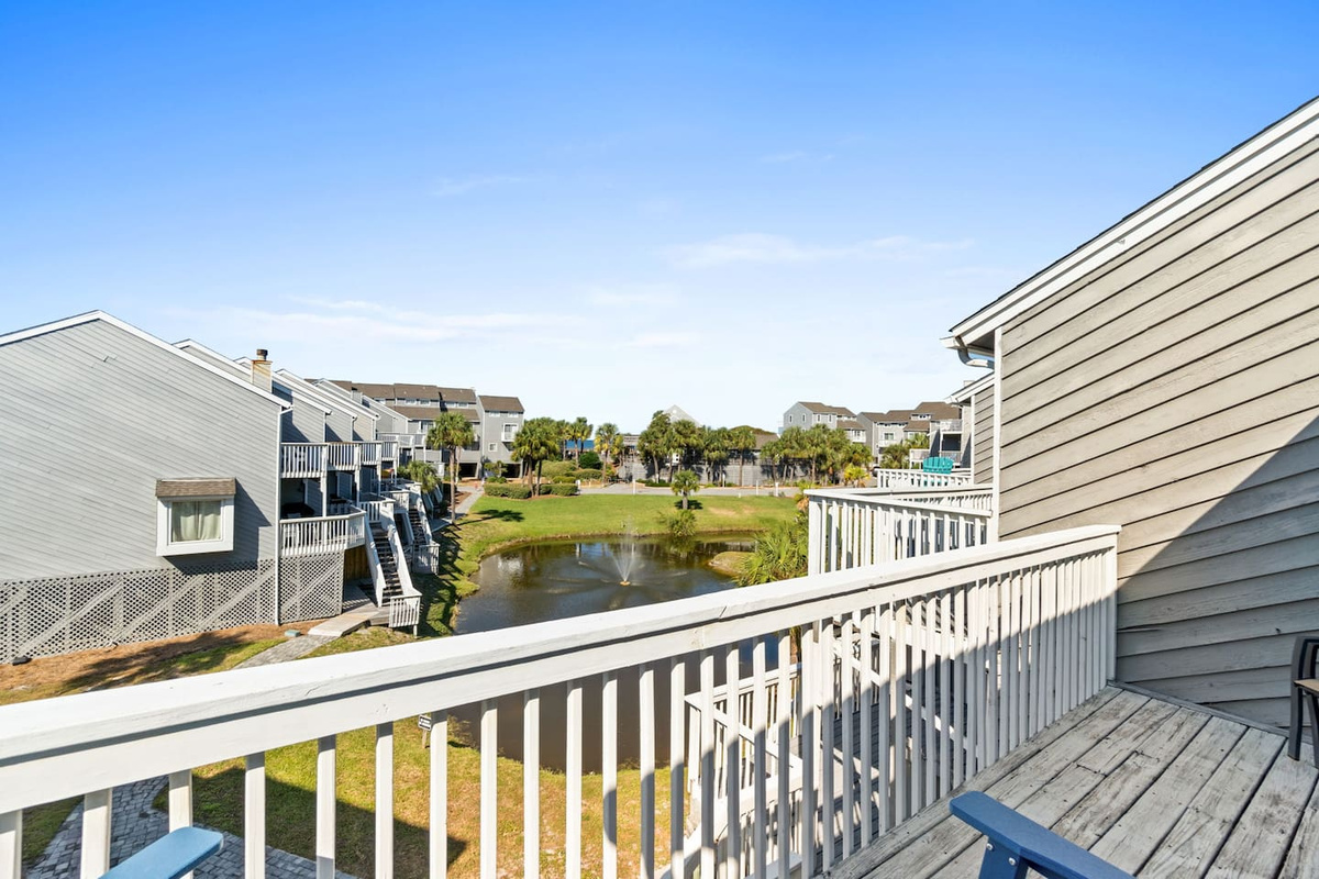 Step out onto your top-floor deck and this is your morning &mdash; lake in the foreground, Gulf shimmering beyond, coffee in hand.
