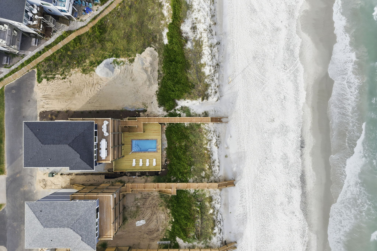 wider aerial showing the home, pool area, and elevated beach access walkway, emphasizing the short, direct path from the property to the ocean