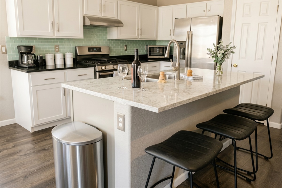 Sleek kitchen island with bar seating and stainless steel appliances — a perfect place for wine and conversation.