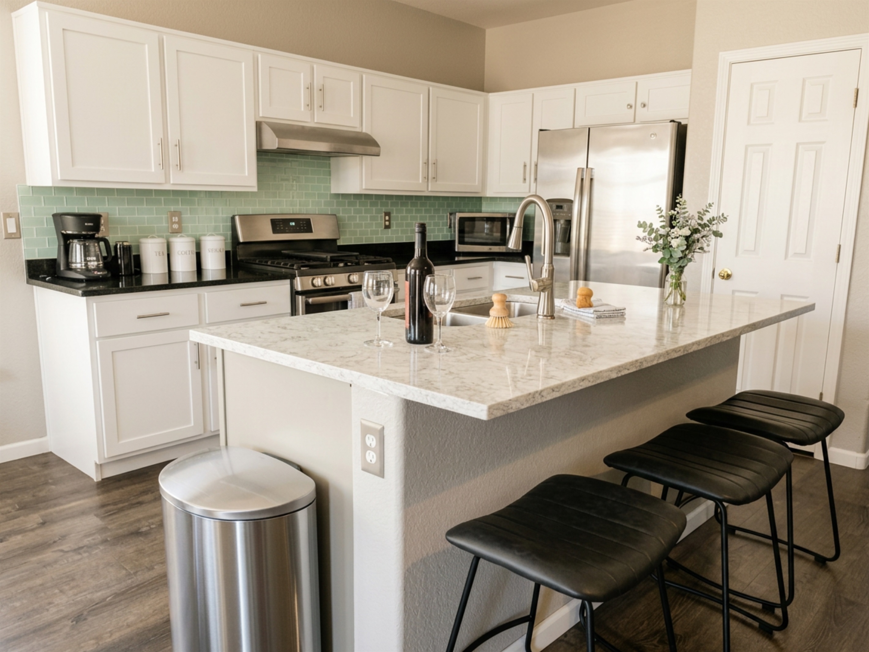 Sleek kitchen island with bar seating and stainless steel appliances — a perfect place for wine and conversation.