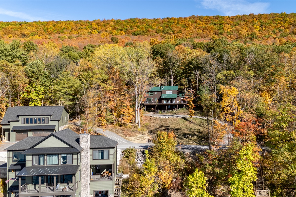 Panoramic view of cabin site amid fall foliage and lake — ultimate Finger Lakes escape.