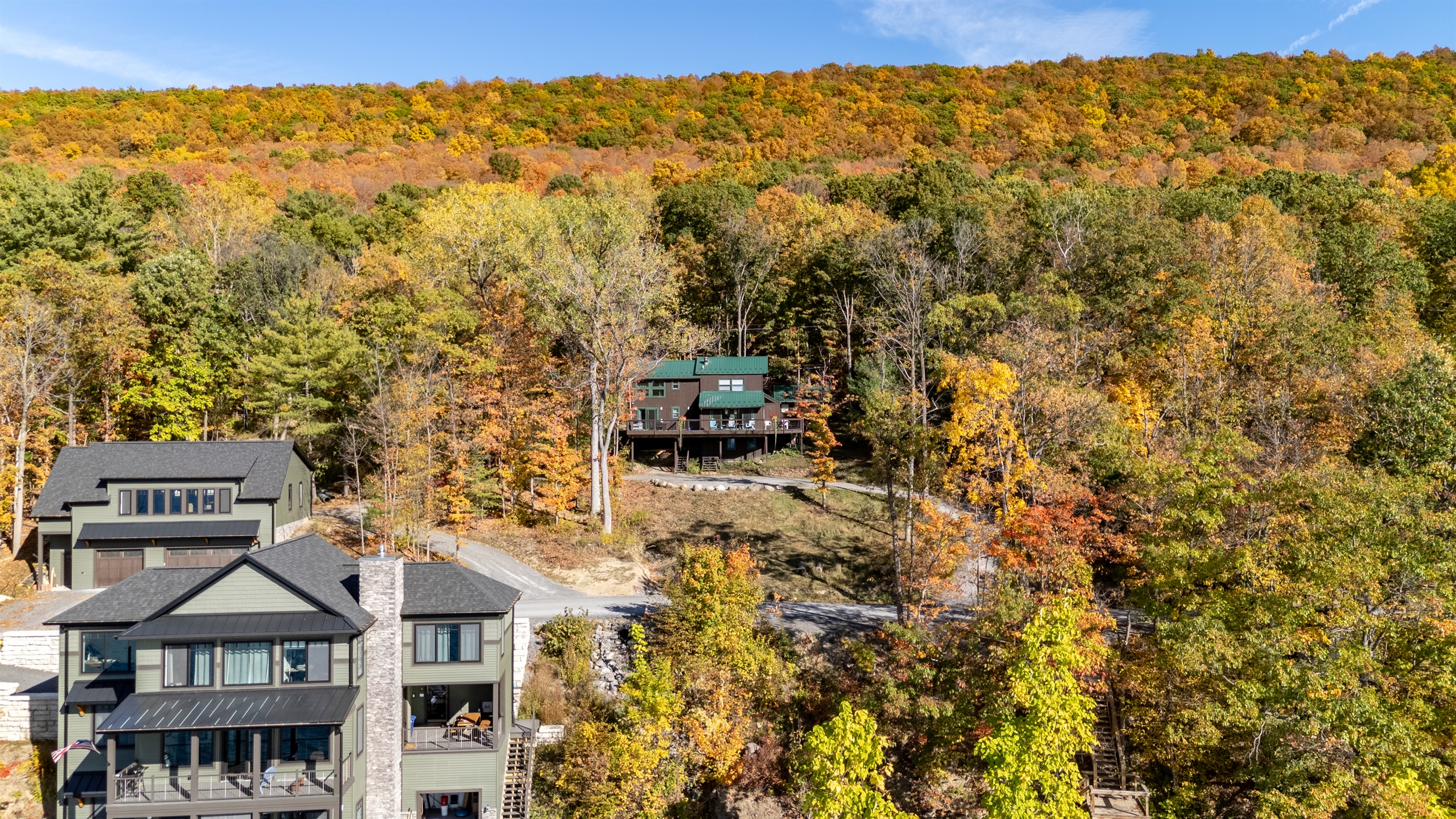 Panoramic view of cabin site amid fall foliage and lake — ultimate Finger Lakes escape.