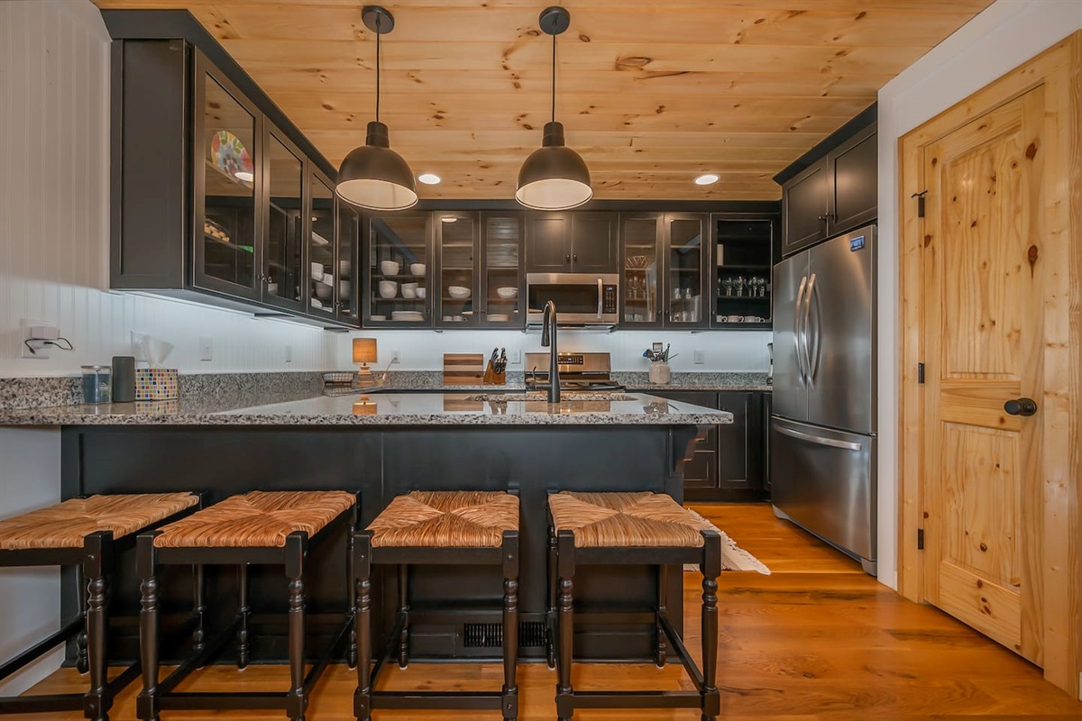Upgraded kitchen area with stainless steal appliances and seating area