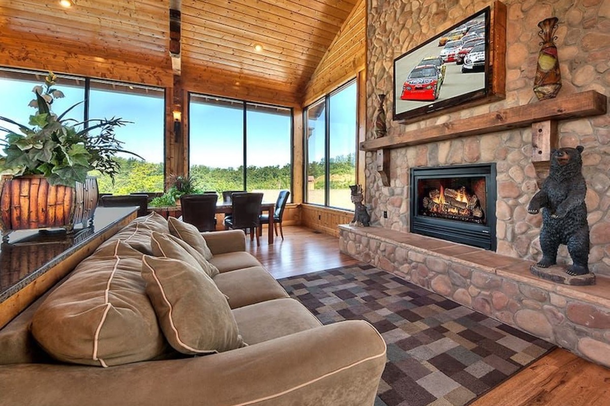 - Cozy lounge with stone fireplace and large windows framing the view   - Watch your favorite shows or unwind by the fire after a mountain day   - Perfect combination of comfort, charm, and breathtaking scenery