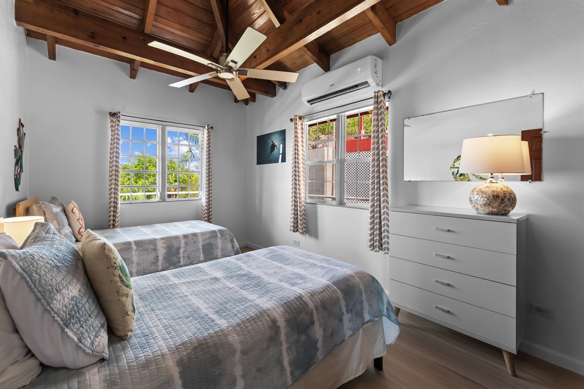 Has two large windows for natural light and an air conditioner  to keep the room cool.