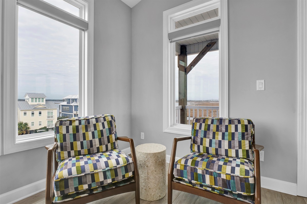Curl up with a good book in this cozy corner featuring a pair of fun, comfortable chairs—perfect for quiet mornings, afternoon reading, or simply relaxing with a cup of coffee.