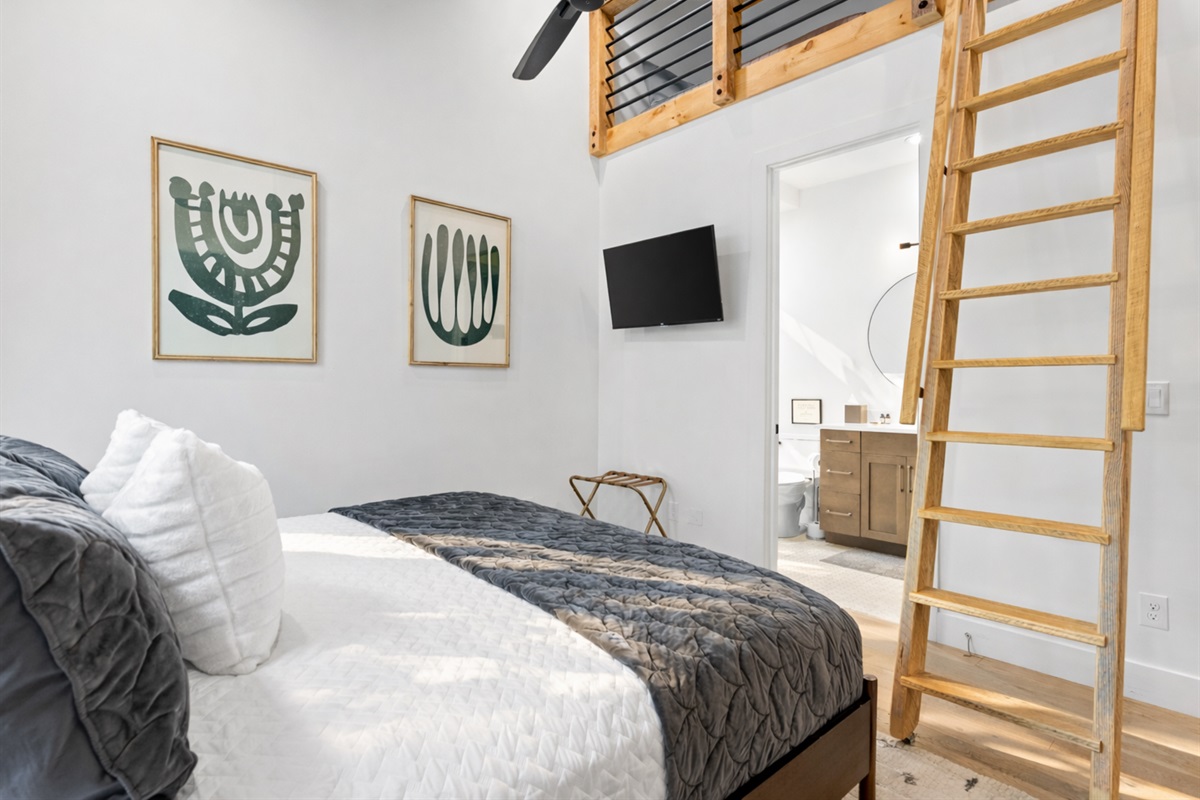 It is a cozy loft-style bedroom with simple decor, providing additional sleeping arrangement on the second level.