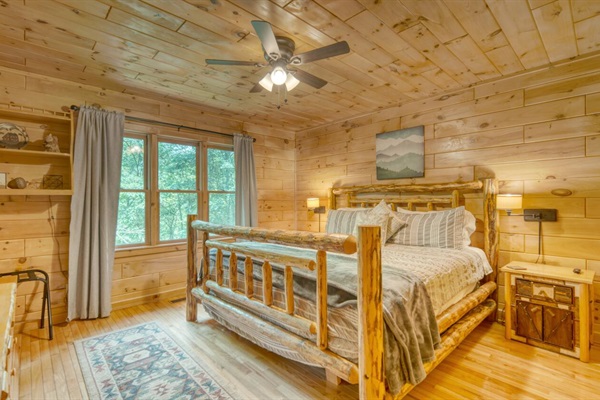 Primary bedroom with king bed, smart tv, and view of the creek