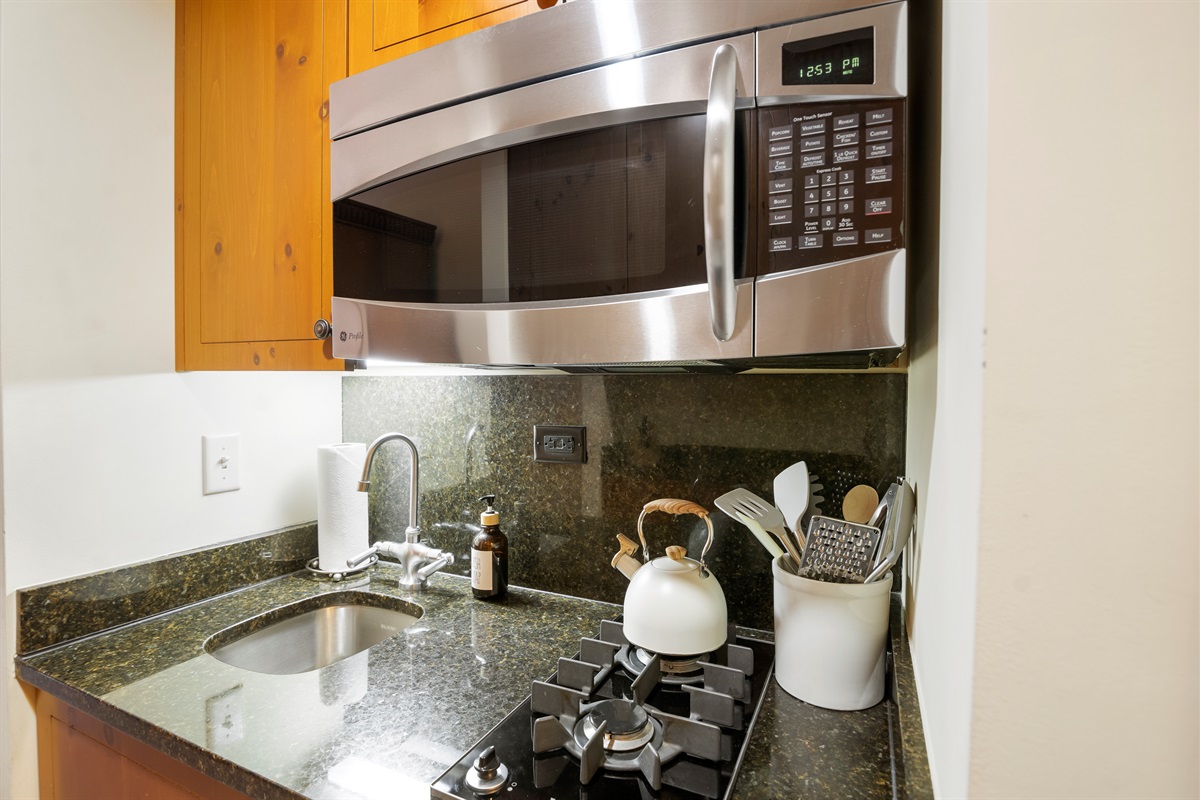 Kitchenette features 2 burner gas stovetop, microwave, dishwasher and hotel size fridge