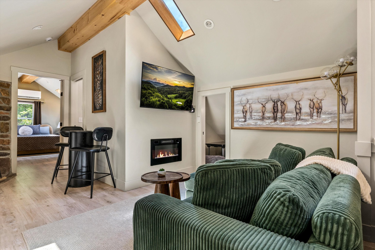 The Penthouse: Cozy Living Room with 55-inch Smart TV, Fireplace, and bistro table.
