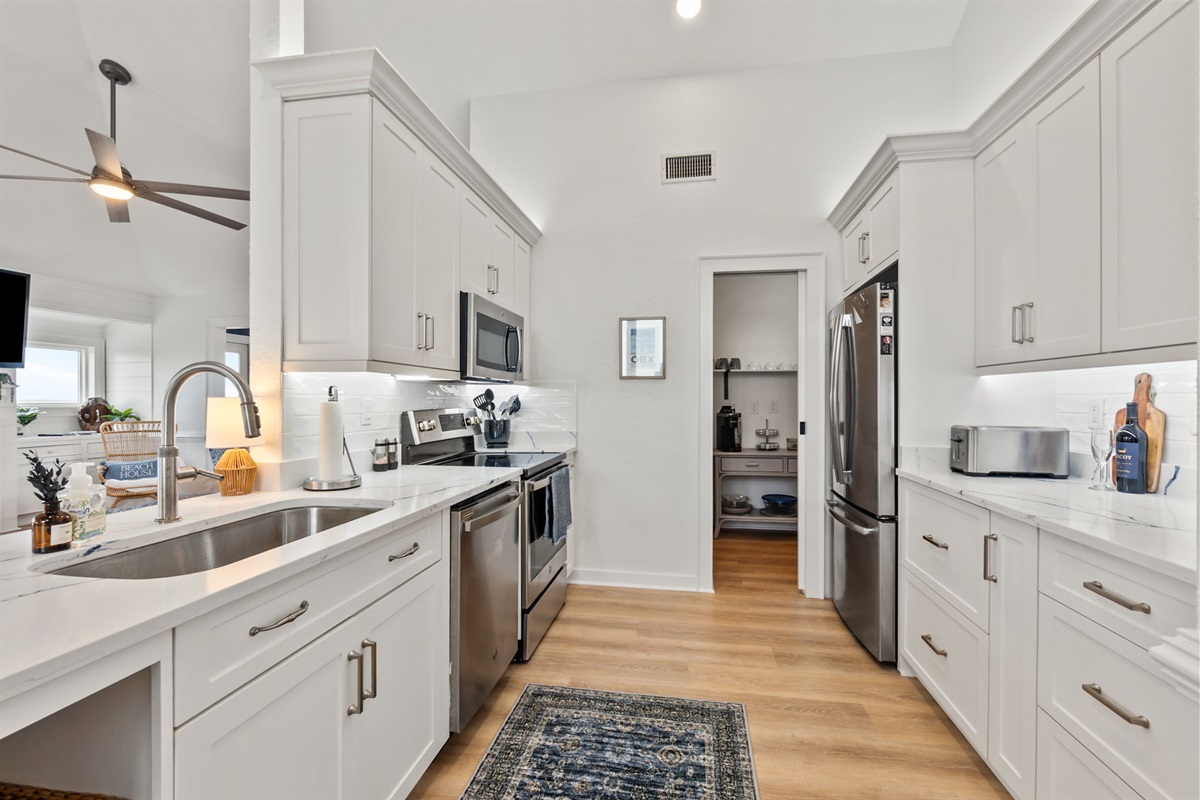 Spacious kitchen with modern appliances, plenty of counter space, and a clean, coastal feel.