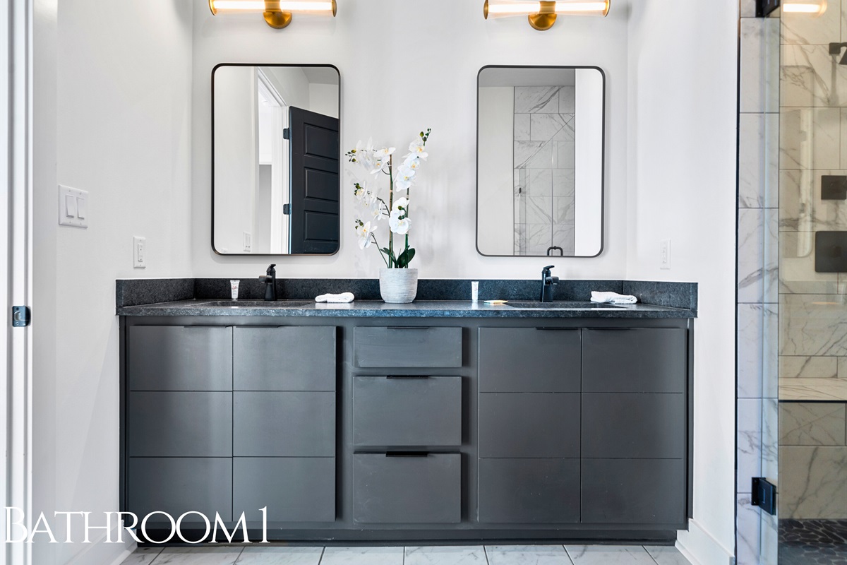 This sleek bathroom combines style and practicality, featuring a spacious double vanity, minimalist finishes, and plenty of natural light for a spa-like feel.