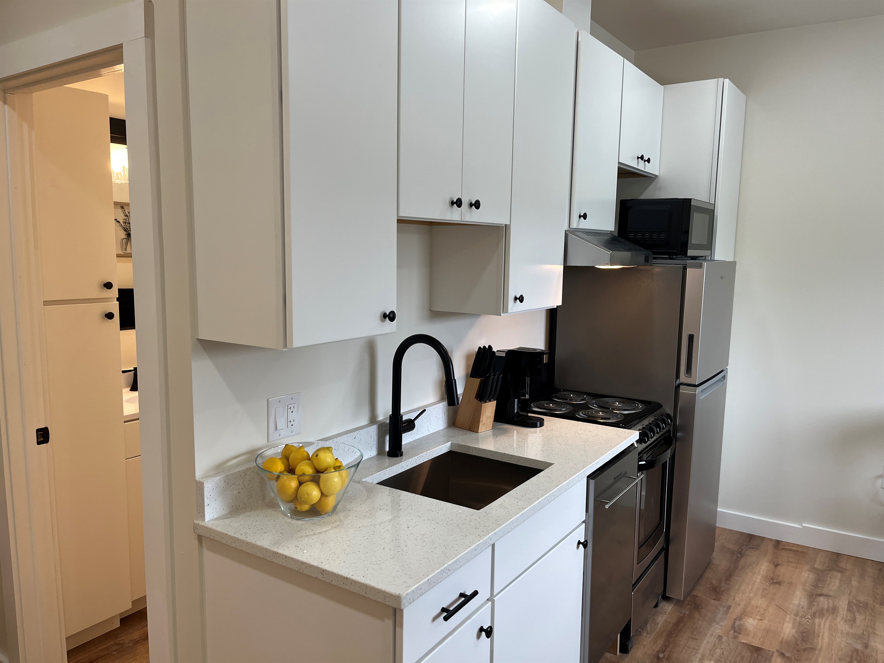 Kitchen area with bathroom beyond
