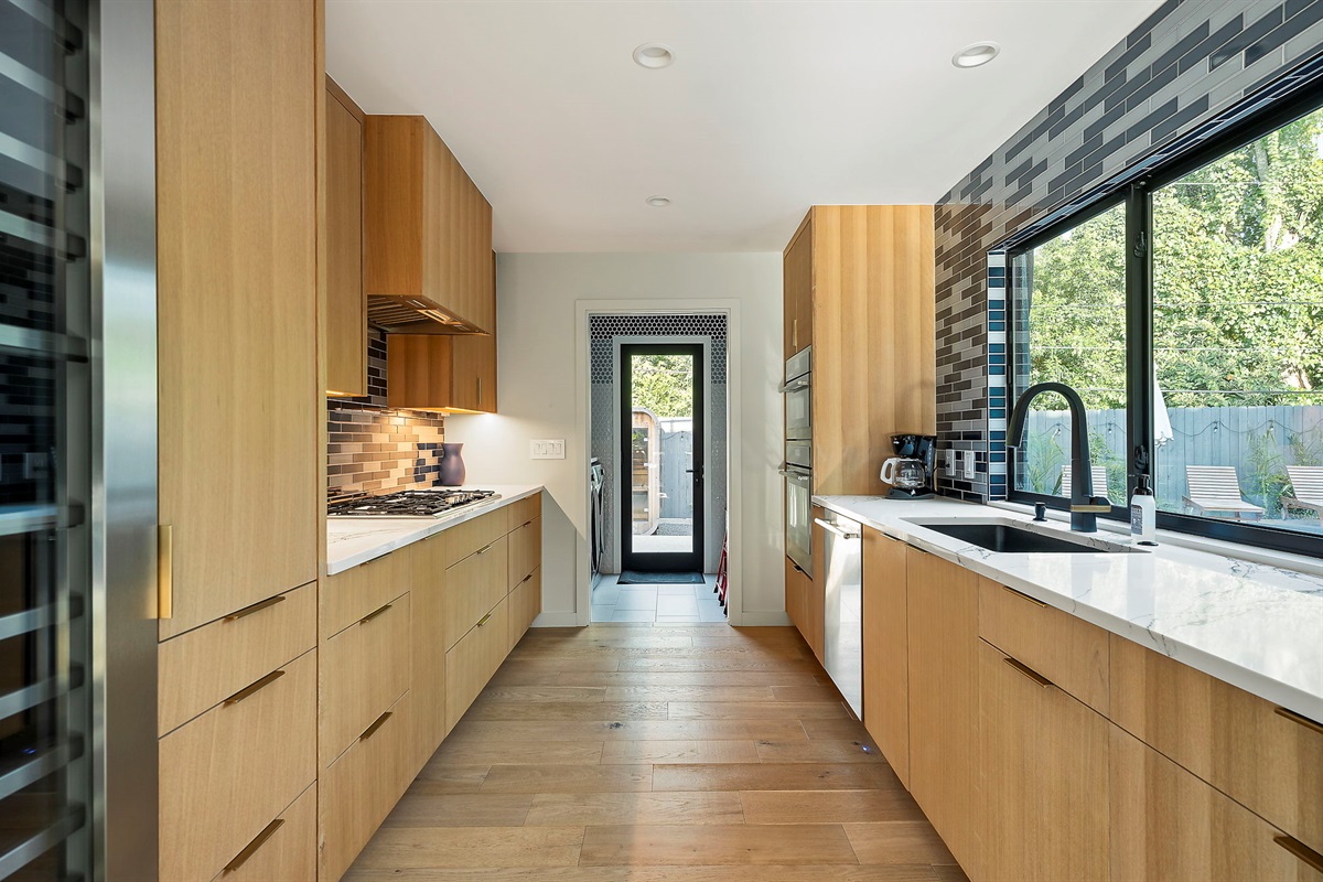 a modern kitchen with dark wood cabinetry and a second with light wood cabinetry