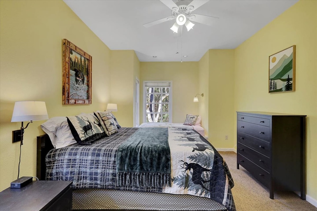 Bedroom 2 with a queen bed, twin bed, and rollaway twin for flexible sleeping space.
